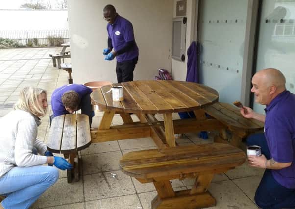 VARNISH Pfizer employees paint picnic tables at Barncroft Primary School