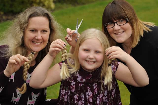 Emma Boothroyde and daughter Elouise Paterson with their locks that were cut off by Rachael Simms, right
Picture: Malcolm Wells (160404-9735)
