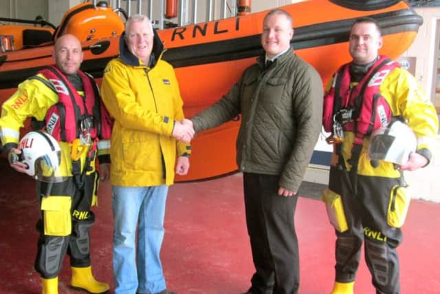 James Lee, Howdens (Havant) branch manager, shaking hands with Jules Hewson at the RNLI Lifeboat Station, with crew members Randall Roake (far left) and Danny MacPherson