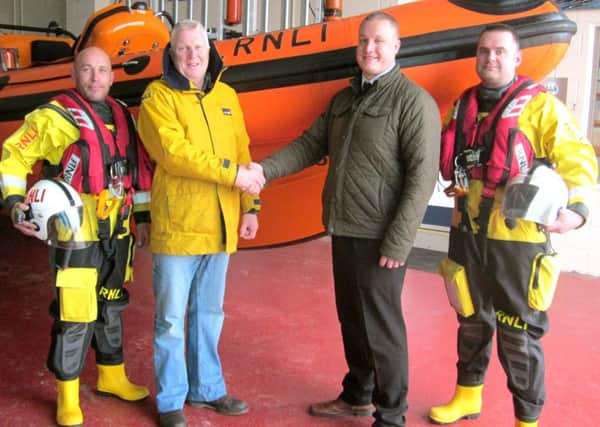 James Lee, Howdens (Havant) branch manager, shaking hands with Jules Hewson at the RNLI Lifeboat Station, with crew members Randall Roake (far left) and Danny MacPherson