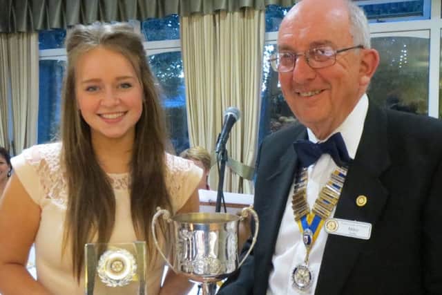 Emily Frost receiving a trophy from Mike Sellis, from Havant Rotary Club