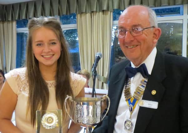Emily Frost receiving a trophy from Mike Sellis, from Havant Rotary Club