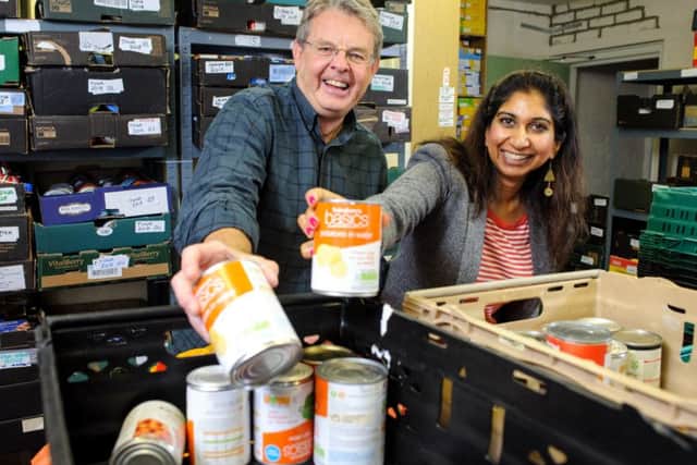 Fareham Food Bank organiser Phil Rutt gets a helping hand to sort donations from MP Suella Fernandes during her visit last year