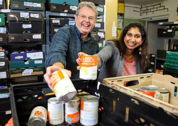 Fareham Food Bank organiser Phil Rutt gets a helping hand to sort donations from MP Suella Fernandes during her visit last year