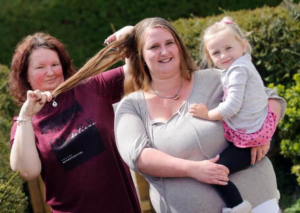 From left, Sarah Carter, Donna Coney and Stevi-Mai Coney, three. 

Donna is getting her head shaved tomorrow to raise money for Cancer Research UK in memory of her dad Martin who died of cancer a year ago

Picture: Allan Hutchings (160411-243)