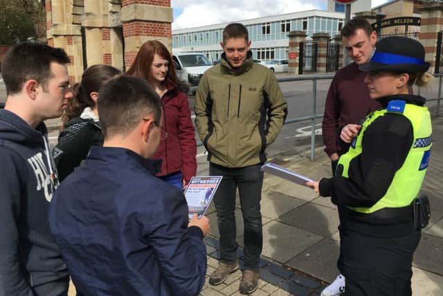 A PCSO stops passersby to ask if they have seen the suspect