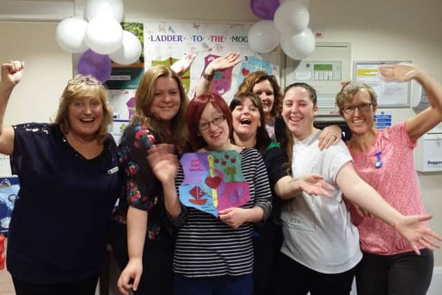Staff at Hamble Heights care home celebrate after activities co-ordinator Vanessa Duggan was presented with a Ladder to The Moon Award for encouraging residents to design a new coat of arms for the home