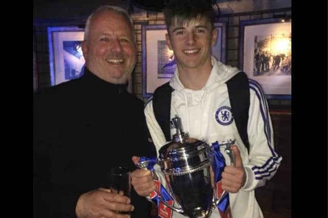 Mason Mount proudly shows off the FA Youth Cup trophy he helped Chelsea win last night, alongside dad Tony