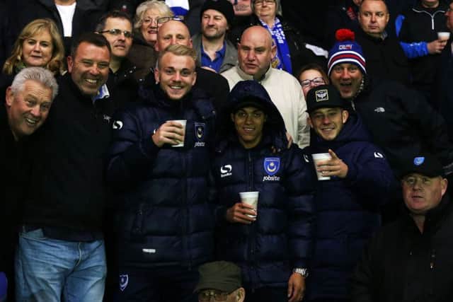 Kyle Bennett, with hood up, alongside Pompey team-mates Jack Whatmough and Conor Chaplin and Blues supporters on the trip to AFC Wimbledons Kingsmeadow on Tuesday night