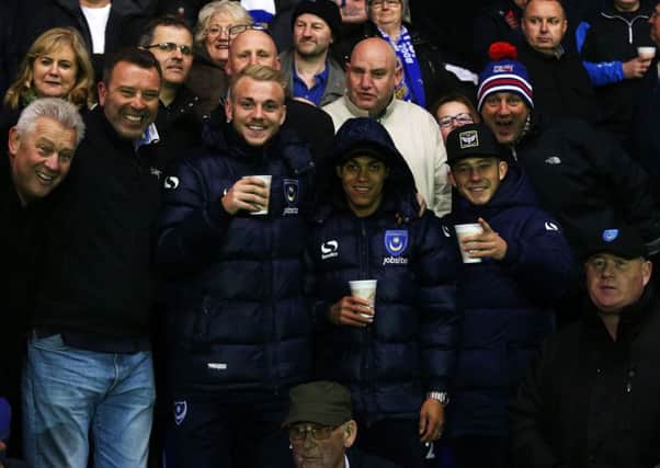 Kyle Bennett, with hood up, alongside Pompey team-mates Jack Whatmough and Conor Chaplin and Blues supporters on the trip to AFC Wimbledons Kingsmeadow on Tuesday night