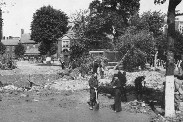 THEN The Royal Naval Barracks, Queen Street after  the raid of August 12, 1940. The Roman CatholiccCathedral can be seen behind the tree on the right.