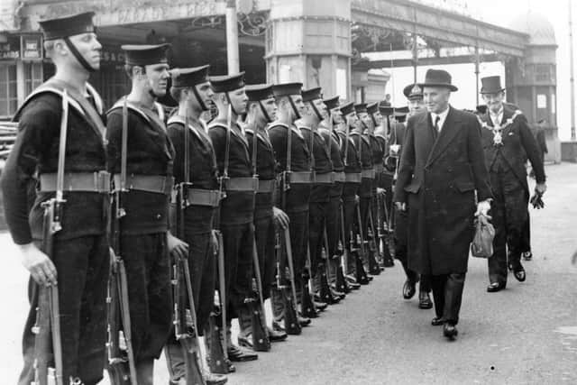 Sir Denis Daly seems to find something amusing as he trails behind Lord Simon inspecting a parade for Ship Week in 1942