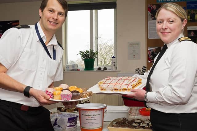 Lieutenant Jen Kedge and Able Rate Andy Hobby offering homemade treats in exchange for donations.Photographer- Keith Woodland, Crown Copyright.