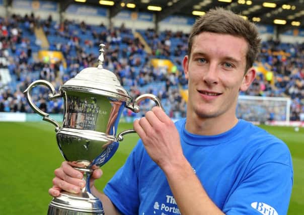 Jason Pearce lifts the coveted Pompey player of the year trophy for the 2011-12 season    Picture: Steve Reid