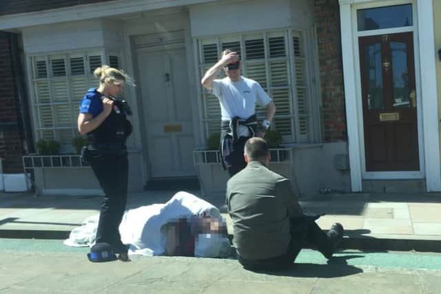 Passers-by tend the injured man in Old Portsmouth