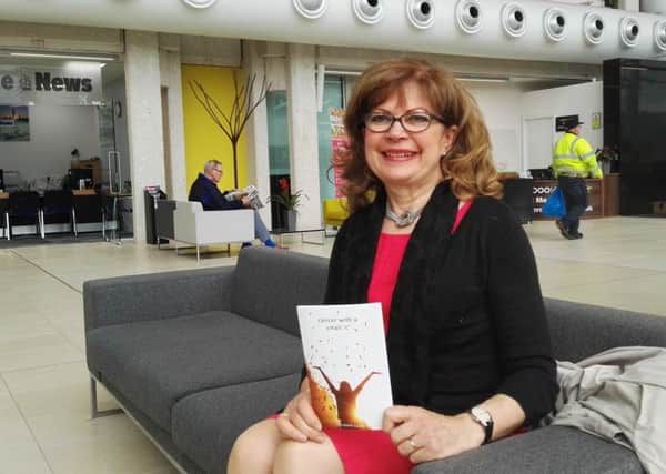 Author Elizabeth Caush with her second book, Cancer with a small c