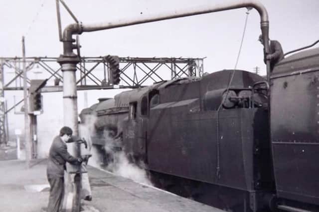 A young John Gardner assisting his driver by filling up the loco tender with water at Basingstoke  in 1967