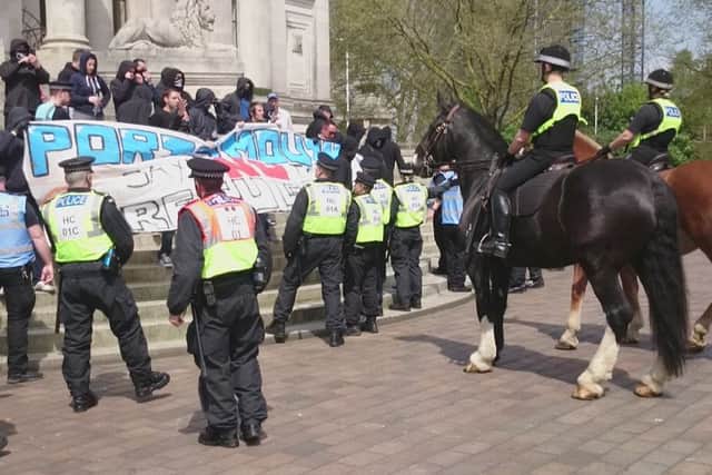 Police keep a watchful eye on protesters on the Guildhall steps