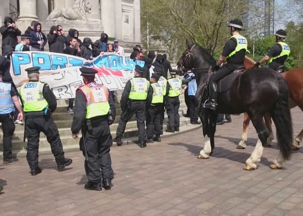 Police keep a watchful eye on protesters on the Guildhall steps
