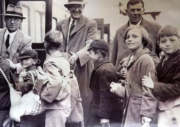 Evacuees boarding a train at  Portsmouth & Southsea low level. Children right to left: Ray Emery with sisters Vilma and Marlene. The  teachers are left to right: Headmaster Mr Davis, Mr  Farrow and Mr Knight