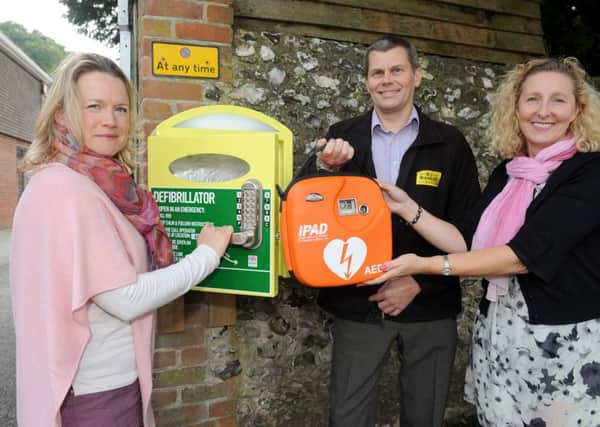 Two defibrillators have been installed in Rowlands Castle following a massive community effort. Pictured is: (l-r) Lisa Walker, clerk at Rowlands Castle Parish Council, Paul Winnicott, who owns the wall where the defibrillator is located and also director of R J Winnicott Ltd and Rowlands Home Hardware and Gill Whatley, admin assistant at Rowlands Castle Parish Council. 

Picture: Sarah Standing (151697-6827)