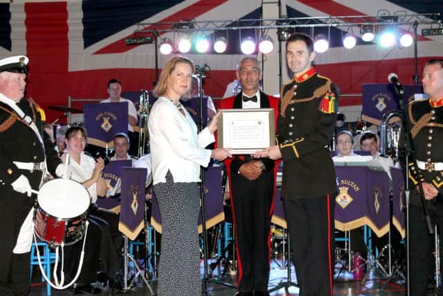 Cdr Sophie Shaughnessy, the Executive Officer of HMS Sultan, with Royal Marine Bugler Kyle Porter and the score of Pedentim, which was written for the 60th anniversary.  Picture: David Berry