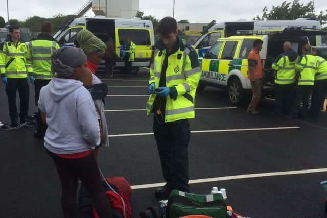 Suspected illegal immigrants are treated by ambulance crews after 28 were discovered in the back of a lorry in Portsmouth