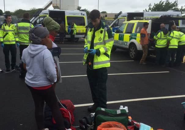 Suspected illegal immigrants are treated by ambulance crews after 28 were discovered in the back of a lorry in Portsmouth