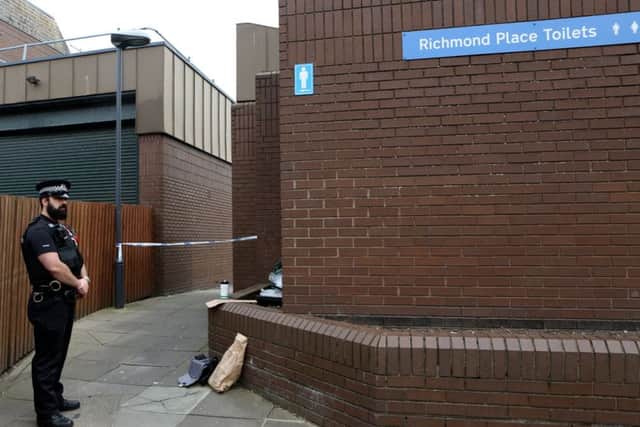 A police officer stands guard outside public toilets in Richmond Place, Southsea, following a robbery