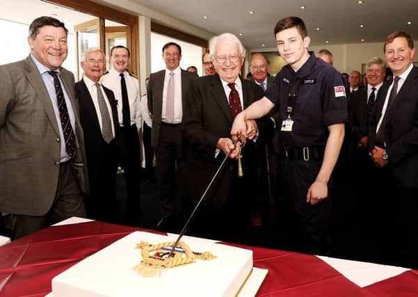 Rear Admiral Lockyer cutting HMS Sultan's 60th anniversary cake with the base's youngest trainee, Engineering Technician Jordan Chaplin