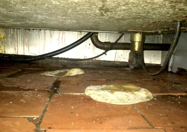 A filthy floor and food debris under a cooker.
