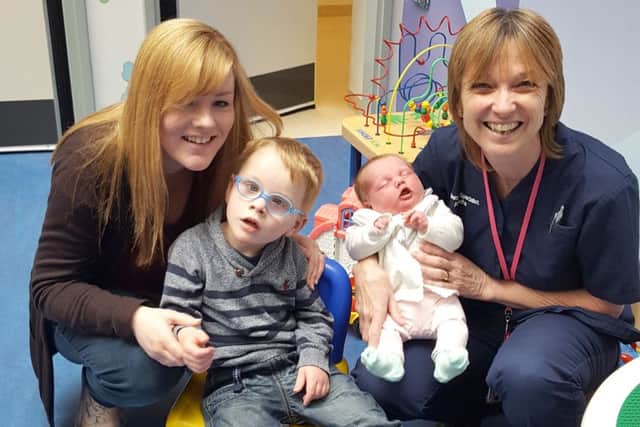 Nikki Legg, left, with her children Jameson and Alice, with QA midwife Ann Going