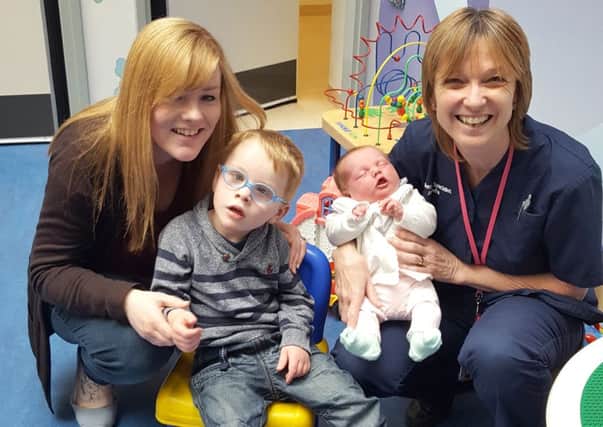 Nikki Legg, left, with her children Jameson and Alice, with QA midwife Ann Going