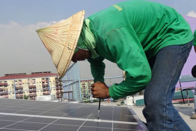 A volunteer installing the solar panels on top of the school in Tondo, Manila. Picture: Rotary Club of Fareham