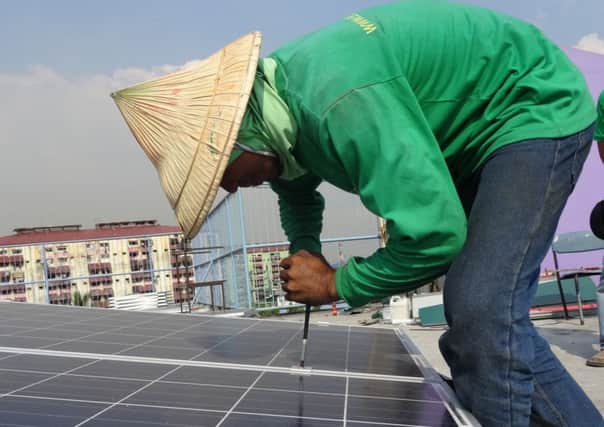 A volunteer installing the solar panels on top of the school in Tondo, Manila.  Picture: Rotary Club of Fareham