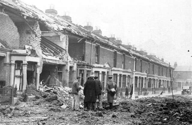 Ewart Road, Buckland, Portsmouth, after the Luftwaffe had paid another visit. Note the girl leaning against the lamp post talking to a friend and the dog in the distance.