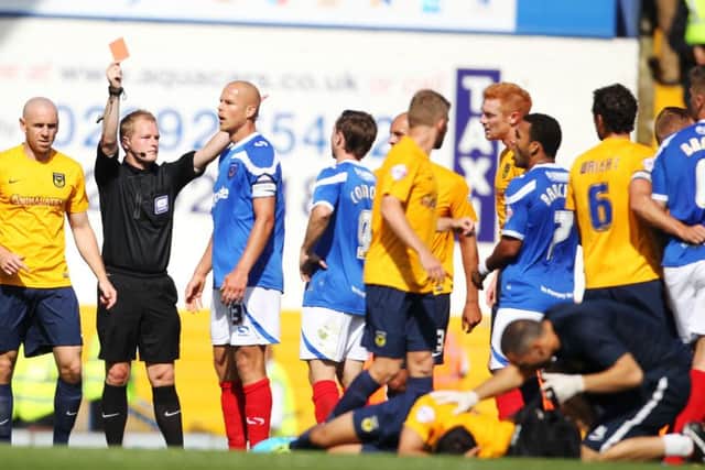 Danny Rose, front, receives treatment from Oxfords physio after being on the receiving end of Johnny Ertls elbow in Pompey's  2013-14 League Two opening-day 4-1 loss   Picture: Joe Pepler