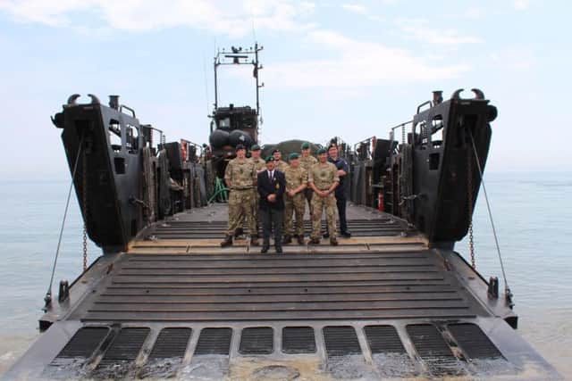 Royal Marines and sailors from HMS Bulwark's Royal Marines squadron gathered on a beach for a commemoration of the loss of landing craft during the 1982 Falklands Conflict
