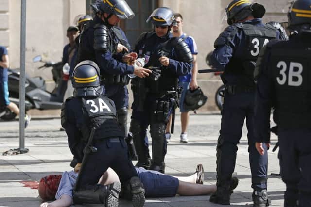 Pompey fan Andrew Bache is assisted by police officers in Marseille after being attacked by Russian hooligans