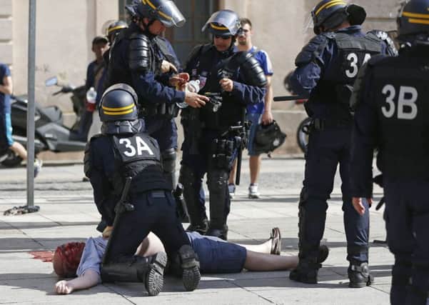 Pompey fan Andrew Bache is assisted by police officers in Marseille after being attacked by Russian hooligans