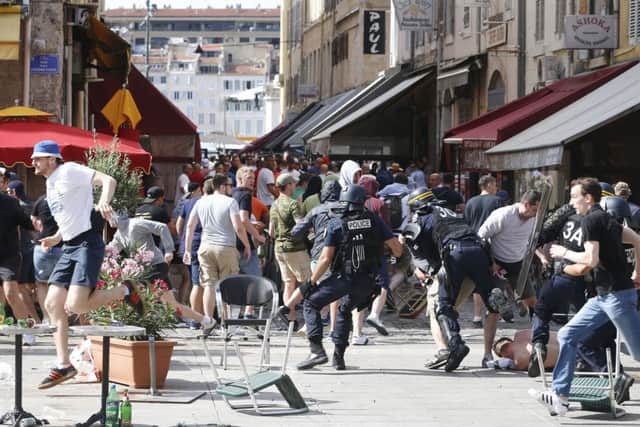 French police officers charge soccer supporters during clashes in downtown Marseille, France