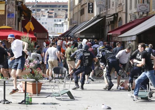 French police officers charge soccer supporters during clashes in downtown Marseille, France