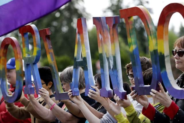 Members of Capital City Pride in Washington and others from the LGBT community hold up letters spelling out "Orlando" to honor of the recent shooting at a gay nightclub (AP Photo/Elaine Thompson)