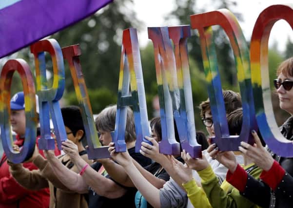 Members of Capital City Pride in Washington and others from the LGBT community hold up letters spelling out "Orlando" to honor of the recent shooting at a gay nightclub (AP Photo/Elaine Thompson)