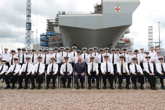 Prince Charles with the ship's company and HMS Prince of Wales in the background