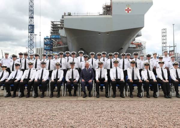 Prince Charles with the ship's company and HMS Prince of Wales in the background