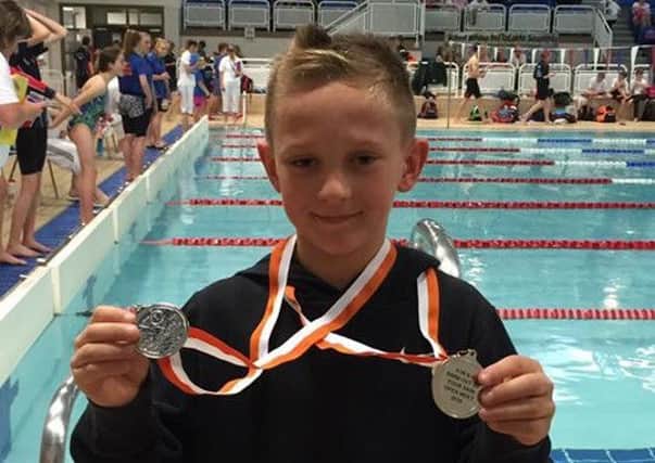 Finlay Norris with his first-ever medals