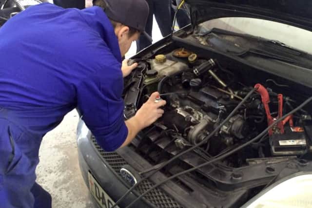 An automotive student pops the bonnet on a car in Highbury College's garage PPP-160630-100833001