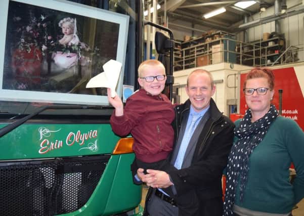 Alex Dunn and his father Chris and mum Helen with the number 74 truck that has Erin's name engraved on it