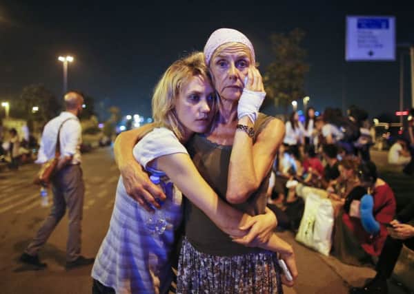Passengers embrace each other as they wait outside Istanbul's Ataturk airport, early Wednesday, June 29, 2016 following their evacuation after a blast. (AP Photo/Emrah Gurel) TURKEY_Explosions_012551.JPG